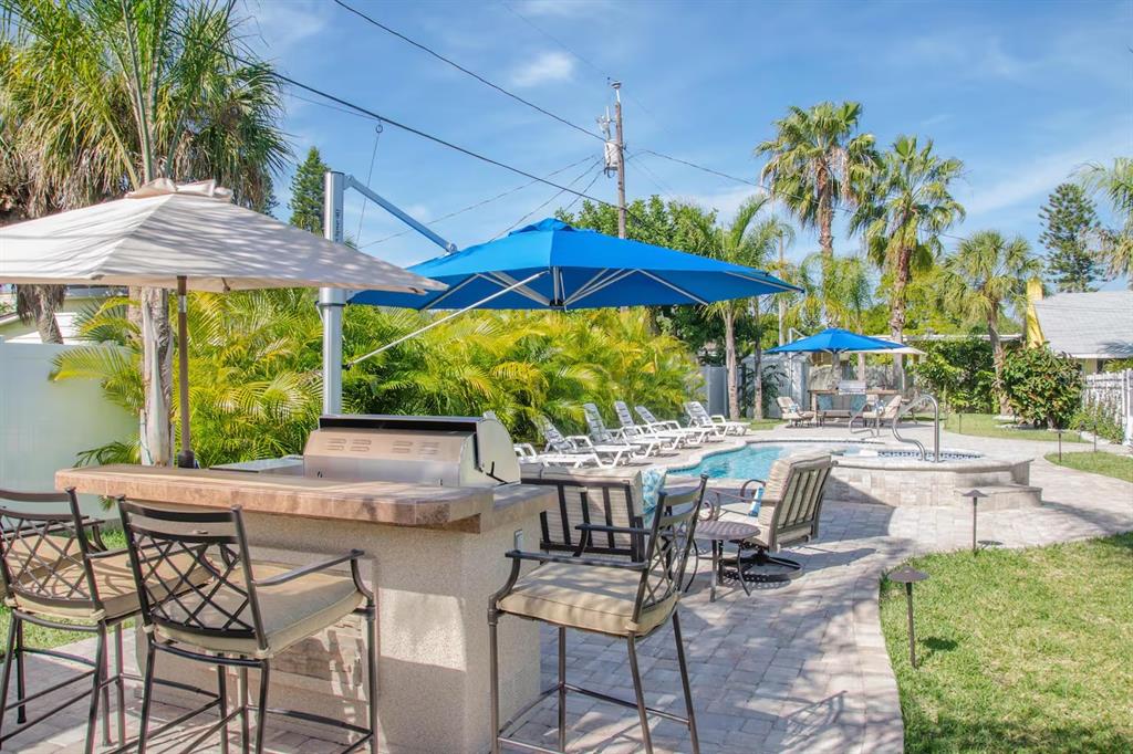 13136 4th Street East Madeira Beach, FL 33708 - Photo 58 of 75 a view of patio with table and chairs under an umbrella