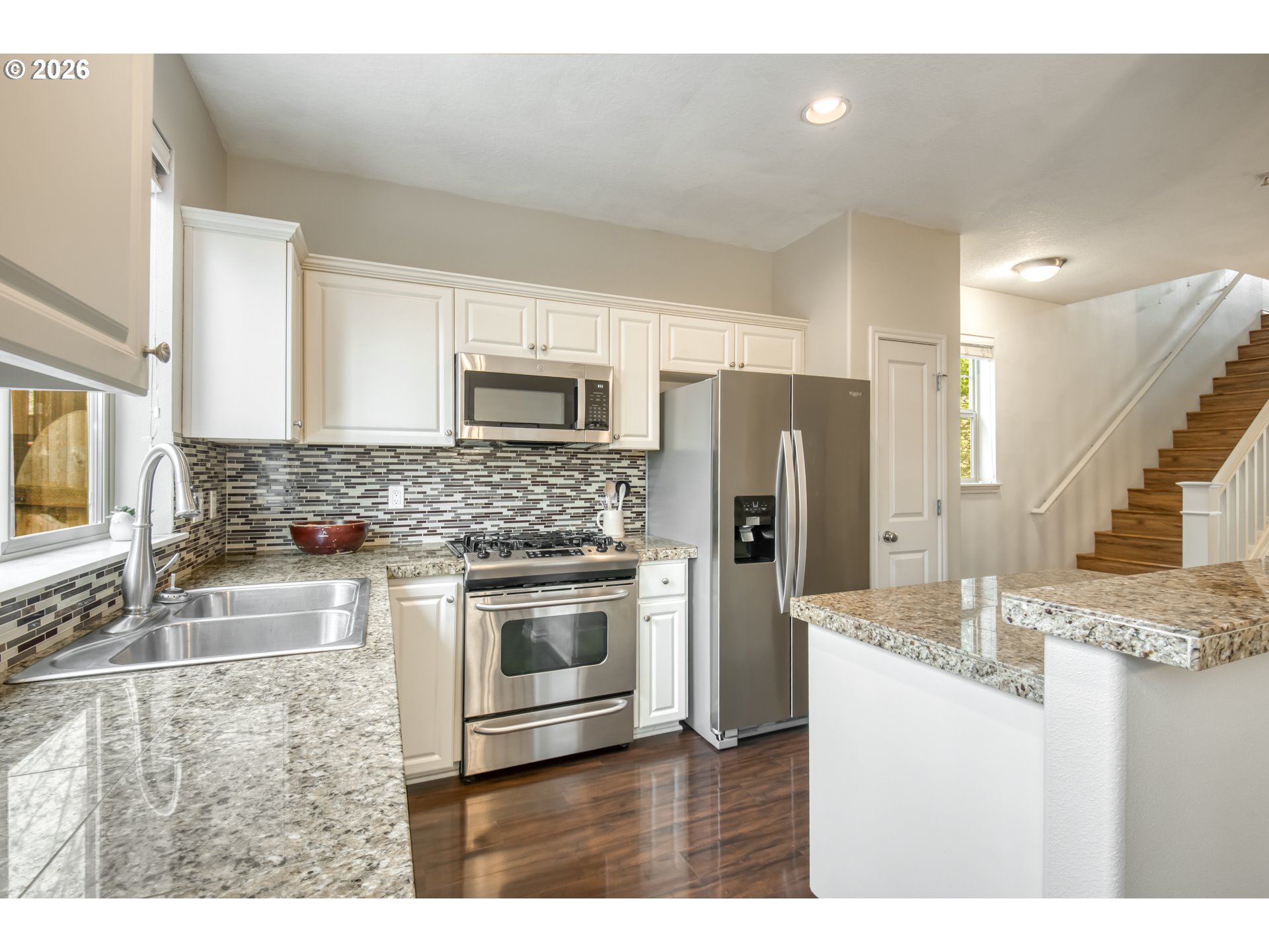 16133 Northwest Hildago Lane Portland, OR 97229 - Photo 6 of 29 a kitchen with kitchen island granite countertop a stove a sink a refrigerator and a microwave