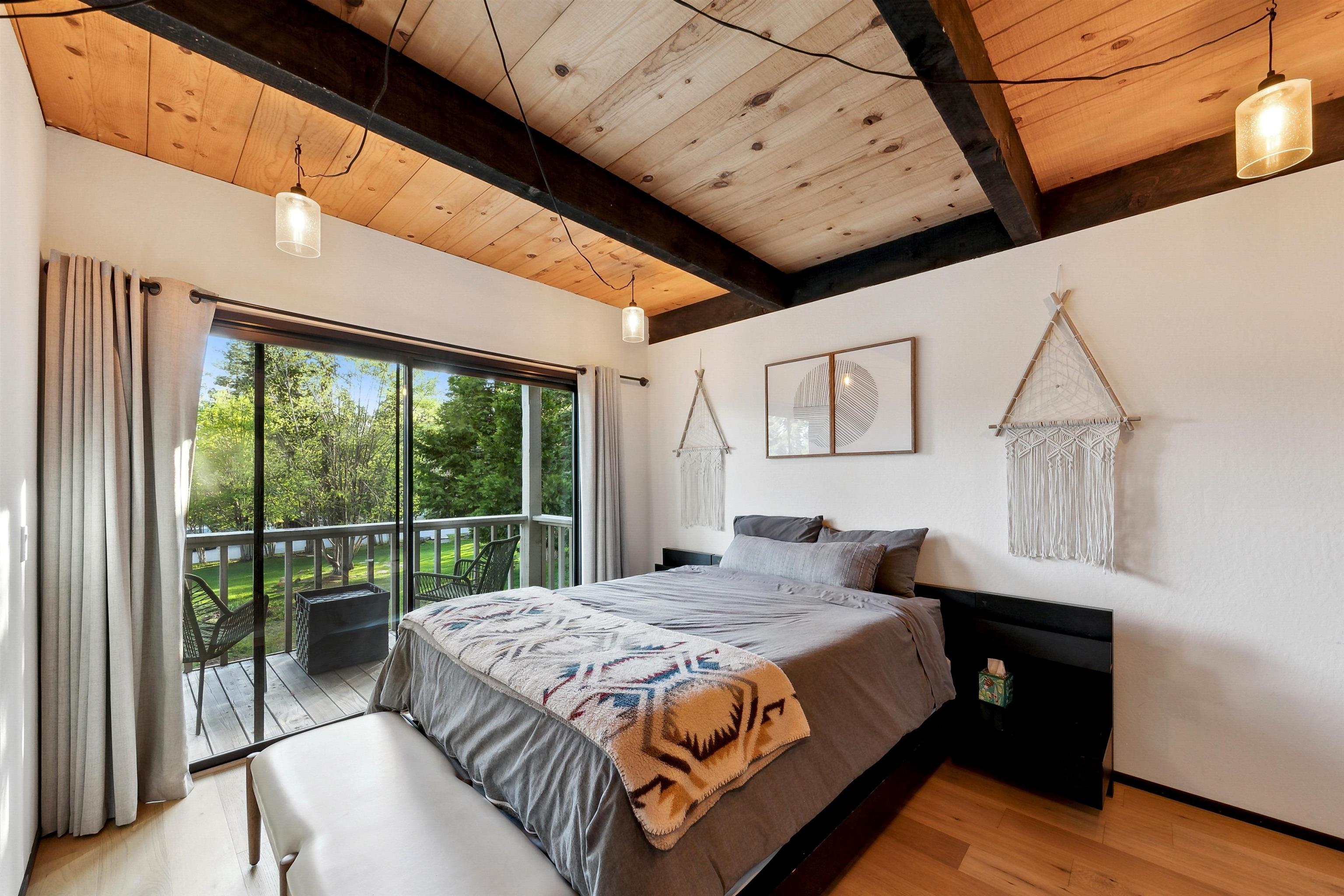 1001 Commonwealth Drive, Unit 218 Kings Beach, CA 96143 - Photo 10 of 28 a bedroom with a bed painting on wall and a large window