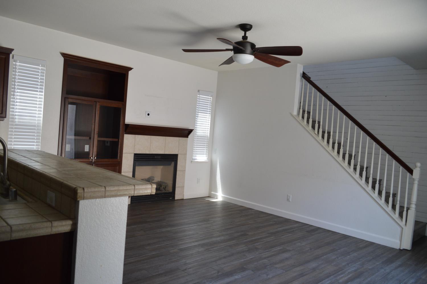 4227 Ivory Lane Turlock, CA 95382 - Photo 15 of 60 a view of a livingroom with fireplace wooden floor and staircase