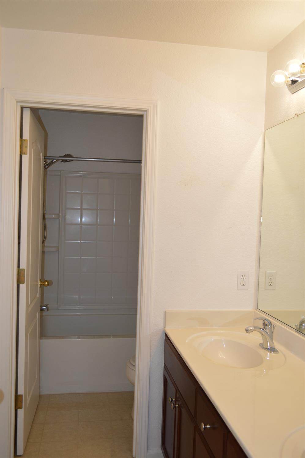 4227 Ivory Lane Turlock, CA 95382 - Photo 31 of 60 a bathroom with a granite countertop sink and a mirror