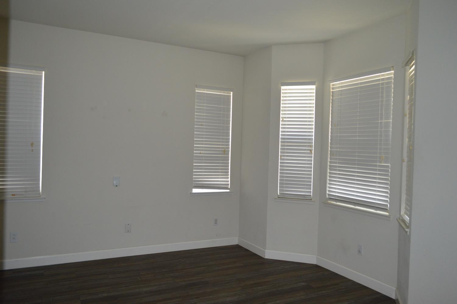 4227 Ivory Lane Turlock, CA 95382 - Photo 5 of 60 a view of an empty room with wooden floor and a window
