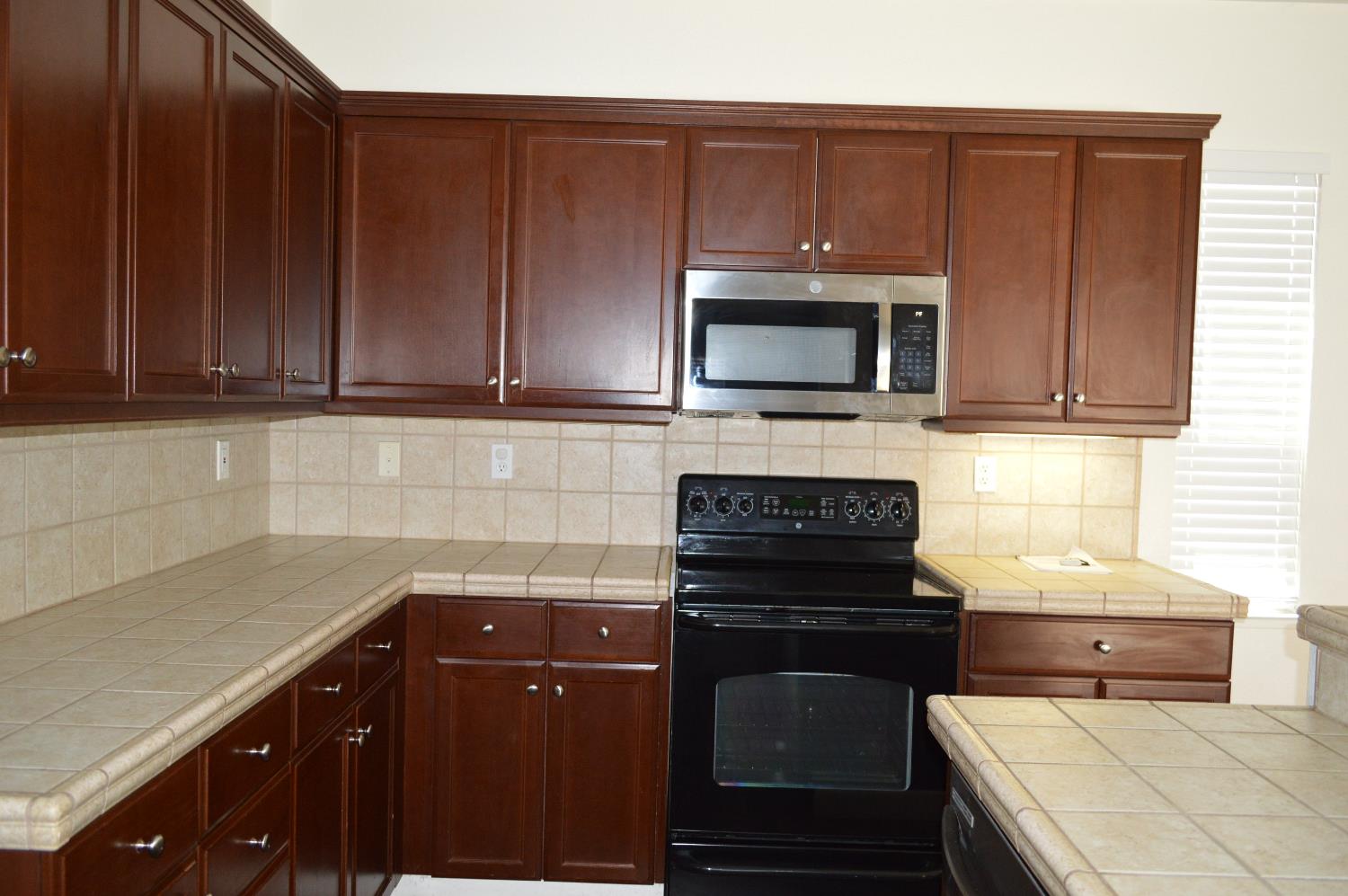 4227 Ivory Lane Turlock, CA 95382 - Photo 10 of 60 a kitchen with a sink stove and microwave