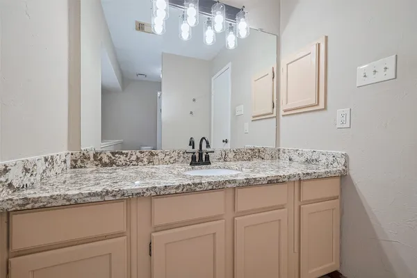 a bathroom with a granite countertop sink and a mirror