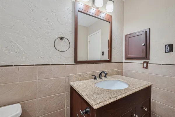 a bathroom with a granite countertop sink and a mirror