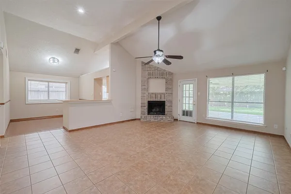 a view of an empty room with a fireplace and a window