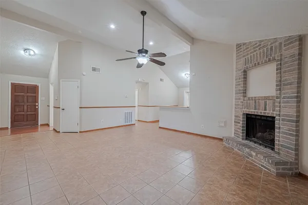 an empty room with fan and fireplace