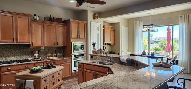 a kitchen with stainless steel appliances granite countertop a stove a sink and a refrigerator