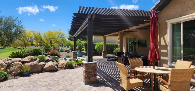 a view of a patio with couches and table and chairs and potted plants