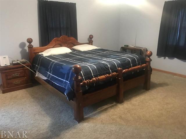 9563 Clintonia Road Clinton, IL 61727 - Photo 12 of 45 a bed sitting in a bedroom next to a window