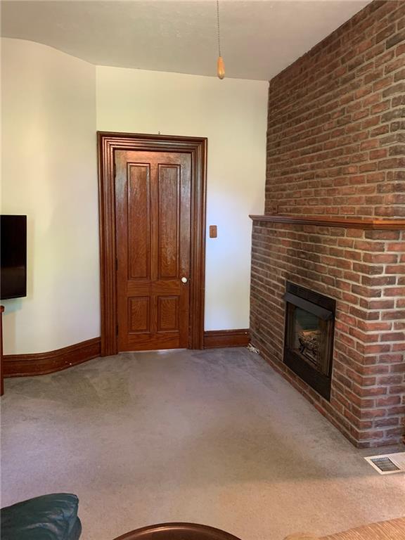 12833 Conneaut Lake Road Conneaut Lake, PA 16316 - Photo 6 of 25 a view of an empty room with wooden floor and a fireplace