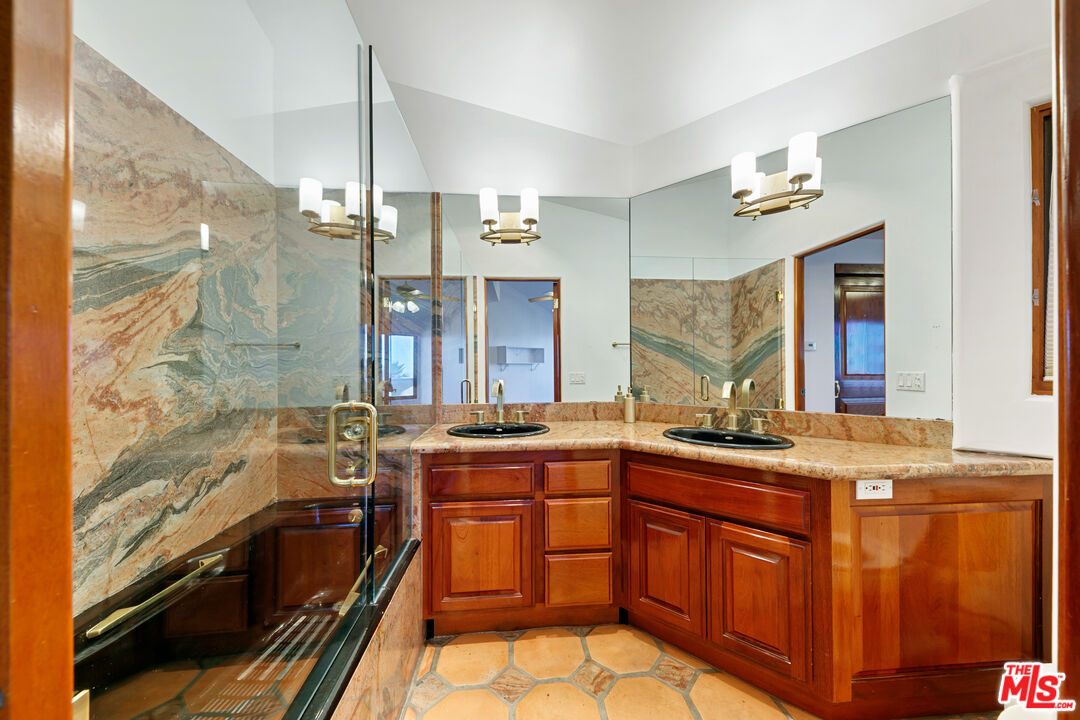 23000 Saddle Peak Road Topanga, CA 90290 - Photo 14 of 26 a bathroom with a double vanity sink a mirror a bathtub and next to a window