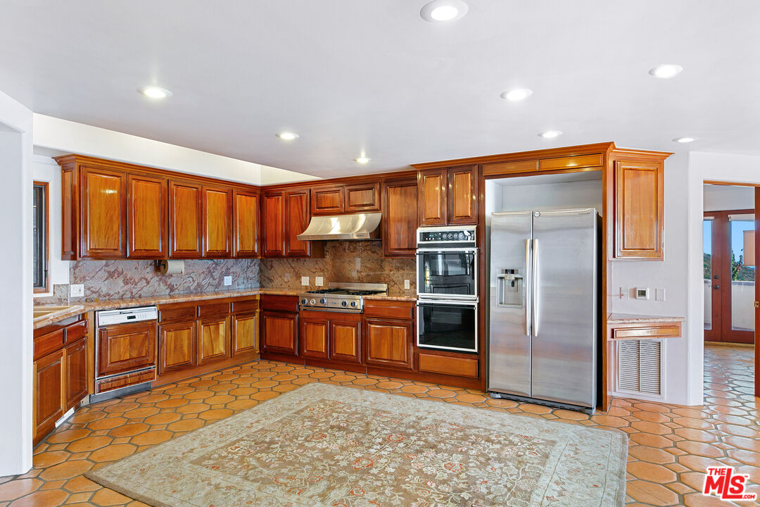 23000 Saddle Peak Road Topanga, CA 90290 - Photo 10 of 26 a large kitchen with stainless steel appliances granite countertop a stove a sink and a refrigerator