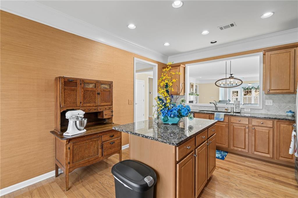 4945 Kings Common Way Cumming, GA 30040 - Photo 15 of 40 a kitchen with stainless steel appliances granite countertop a sink stove and cabinets
