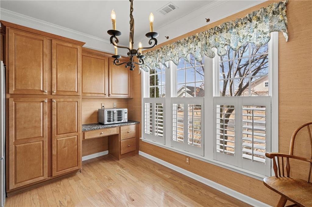 4945 Kings Common Way Cumming, GA 30040 - Photo 17 of 40 a view of a kitchen with stainless steel appliances wooden floor and chandelier
