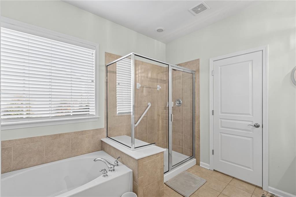 4945 Kings Common Way Cumming, GA 30040 - Photo 23 of 40 a bathroom with a bathtub and a shower