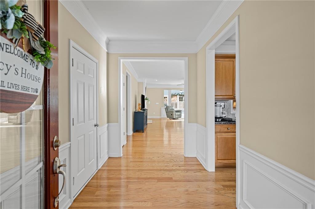 4945 Kings Common Way Cumming, GA 30040 - Photo 6 of 40 a hallway with wooden floor fireplace and living room