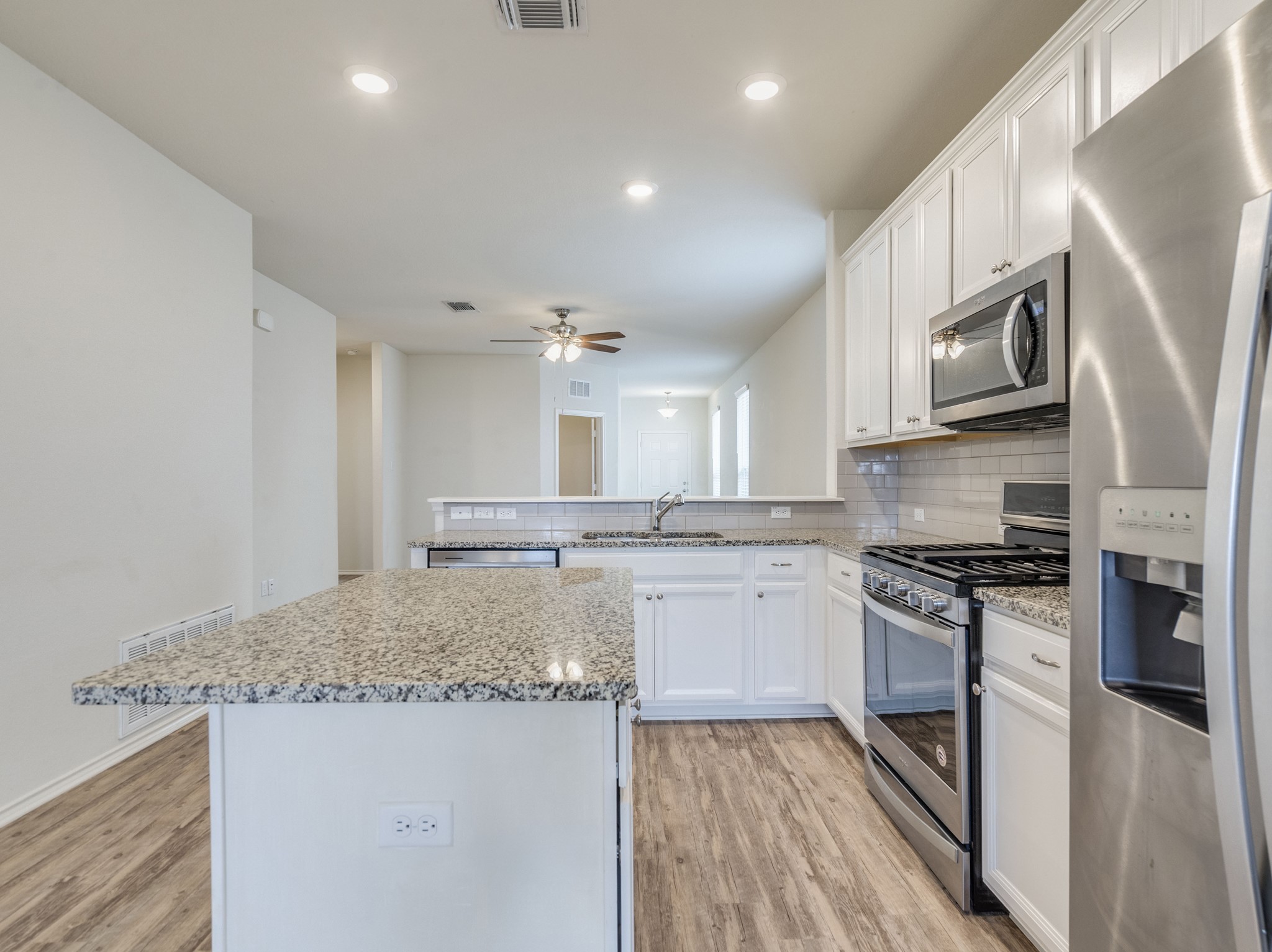 790 Pepperbark Loop Buda, TX 78610 - Photo 6 of 22 Culinary delights await in this modern kitchen with granite island and stainless steel appliances.
