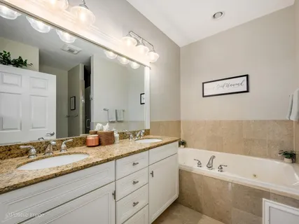 a bathroom with a tub sink and mirror
