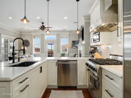 a kitchen with stainless steel appliances granite countertop a sink a stove and cabinets