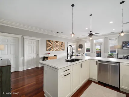 a kitchen with stainless steel appliances granite countertop a sink a stove and a wooden floor