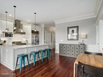 a large kitchen with kitchen island a stove a sink a center island and wooden floor
