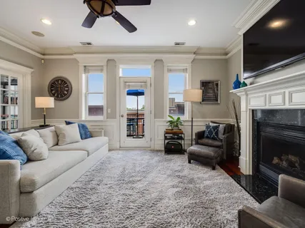a living room with furniture a flat screen tv and a fireplace