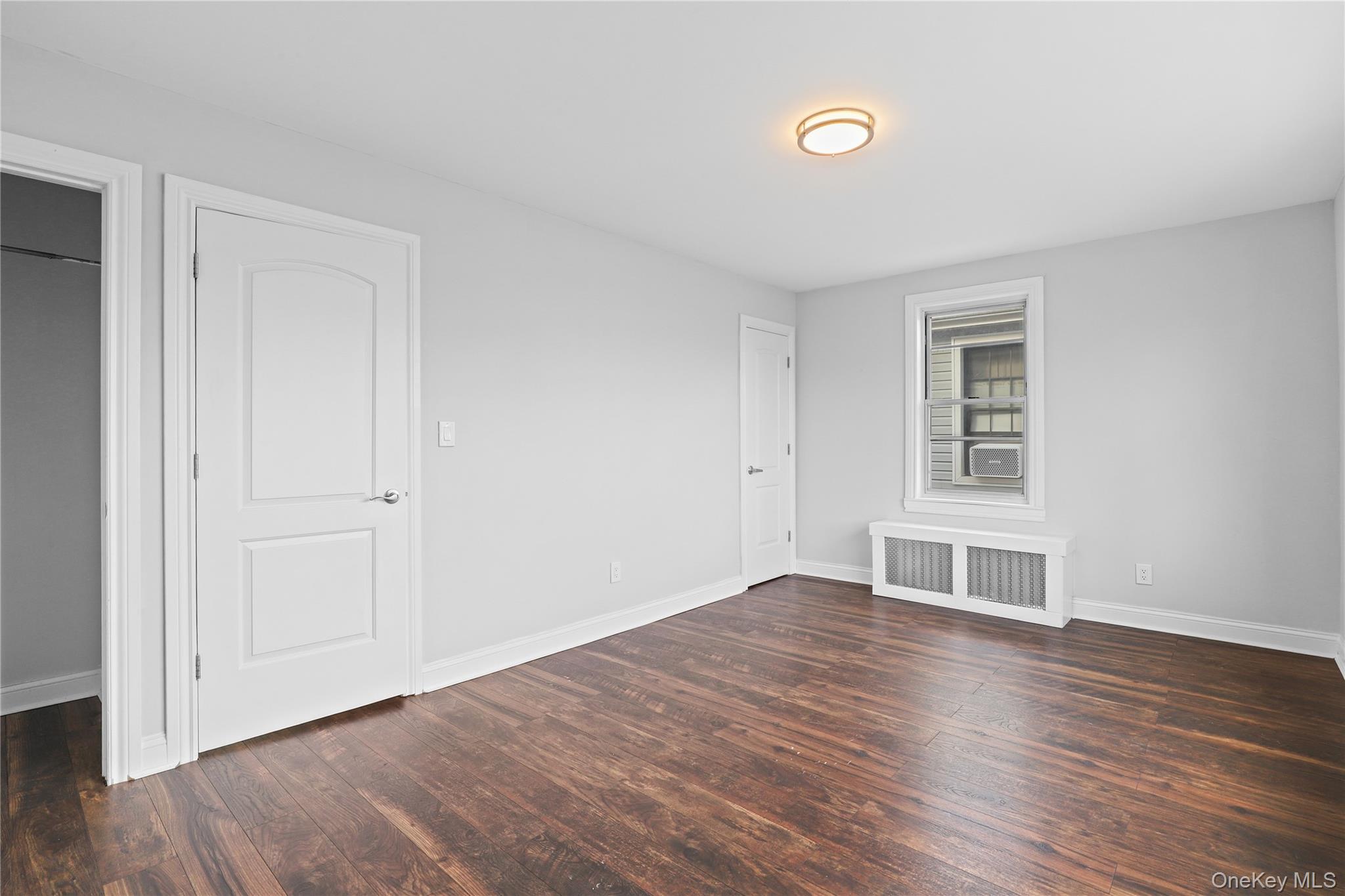 1631 Paulding Avenue Bronx, NY 10462 - Photo 14 of 22 an empty room with wooden floor closet and windows