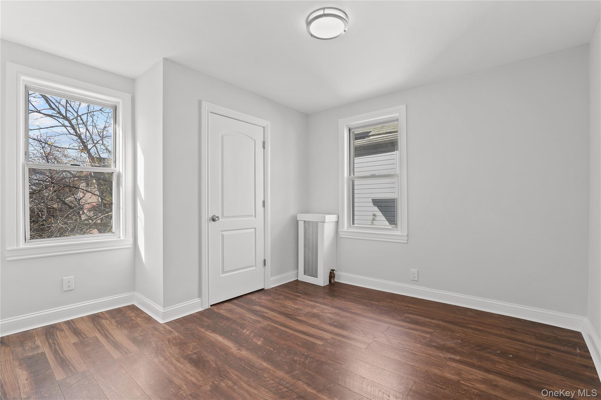 1631 Paulding Avenue Bronx, NY 10462 - Photo 16 of 22 an empty room with wooden floor and windows