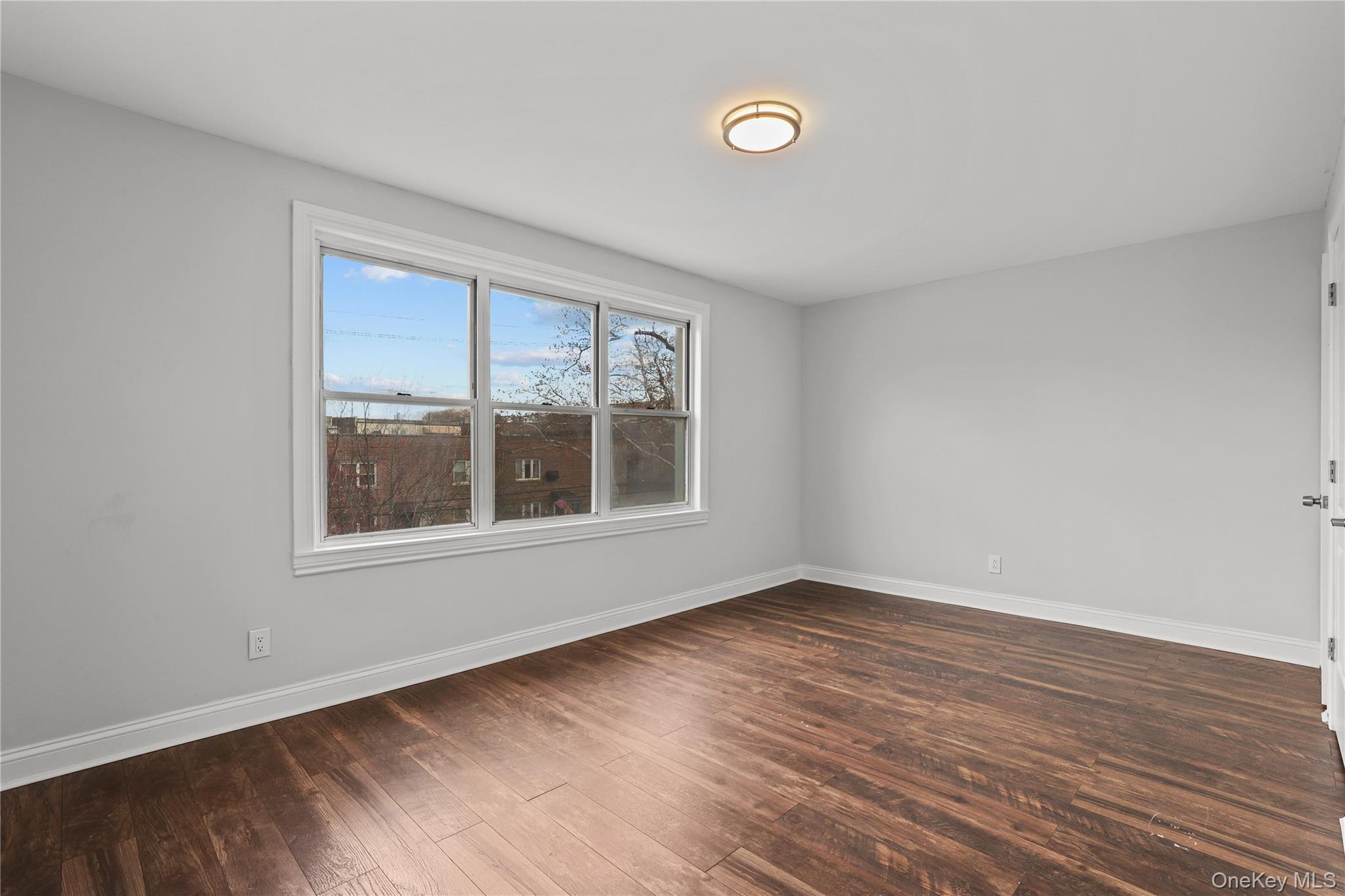 1631 Paulding Avenue Bronx, NY 10462 - Photo 18 of 22 an empty room with wooden floor and windows