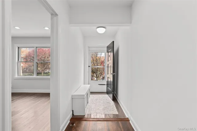 a view of a hallway with wooden floor and a living room
