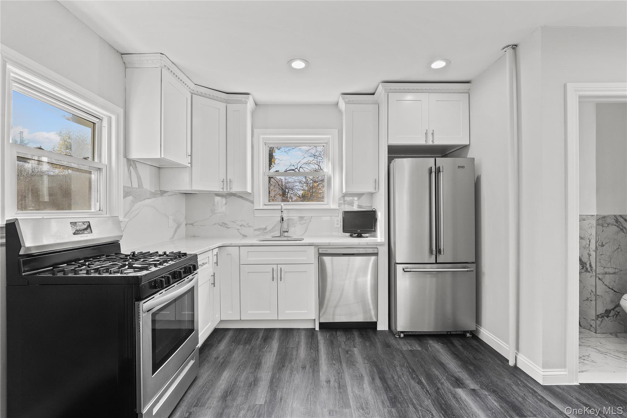 1631 Paulding Avenue Bronx, NY 10462 - Photo 6 of 22 a kitchen with white cabinets a refrigerator and a stove top oven