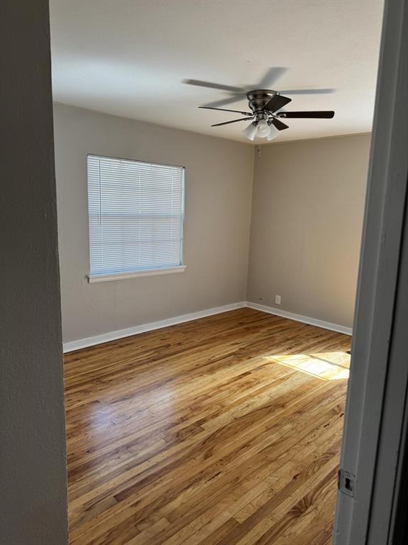 8427 Ridgelea Street Dallas, TX 75209 - Photo 7 of 17 en empty room with wooden floor fan and windows