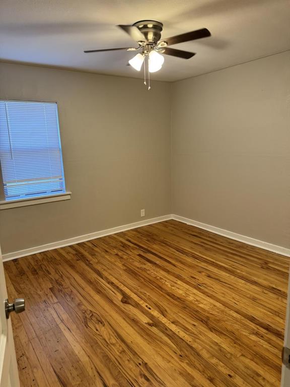 8427 Ridgelea Street Dallas, TX 75209 - Photo 9 of 17 a view of a room with a ceiling fan and a wooden floor