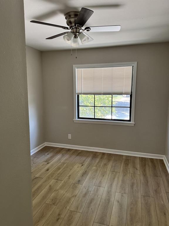 8427 Ridgelea Street Dallas, TX 75209 - Photo 10 of 17 an empty room with wooden floor chandelier fan and windows