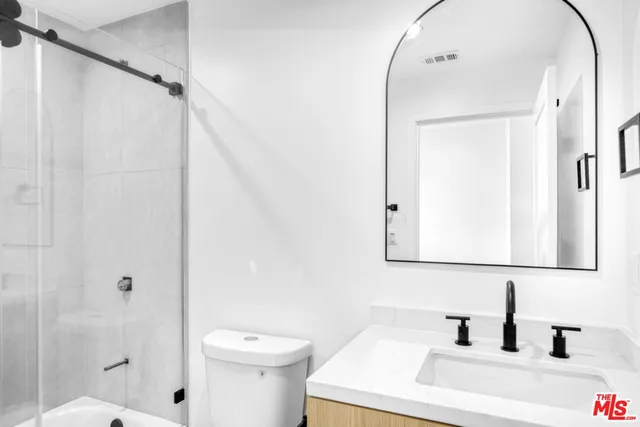 a bathroom with a sink a toilet and shower