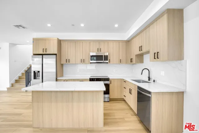 a kitchen with stainless steel appliances granite countertop a sink stove and refrigerator