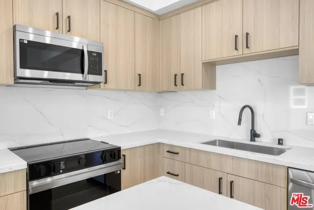 a kitchen with appliances a sink and cabinets