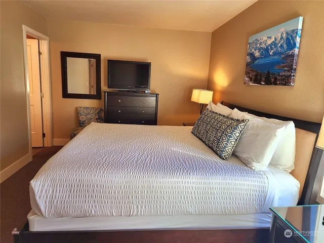 a bedroom with a bed and a flat screen tv