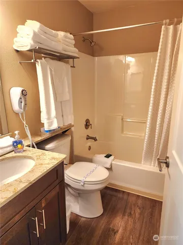 a bathroom with a granite countertop sink toilet and shower