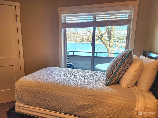 a bedroom with a bed and a large window