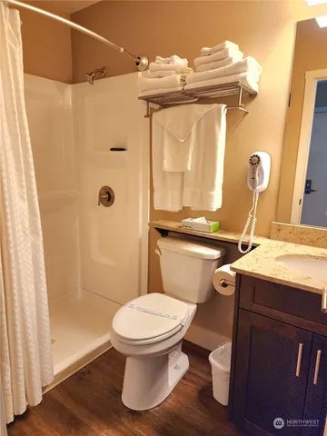 a bathroom with a sink a toilet and shower