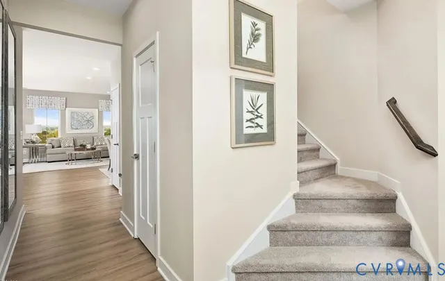 a view of a hallway with wooden floor and a living room