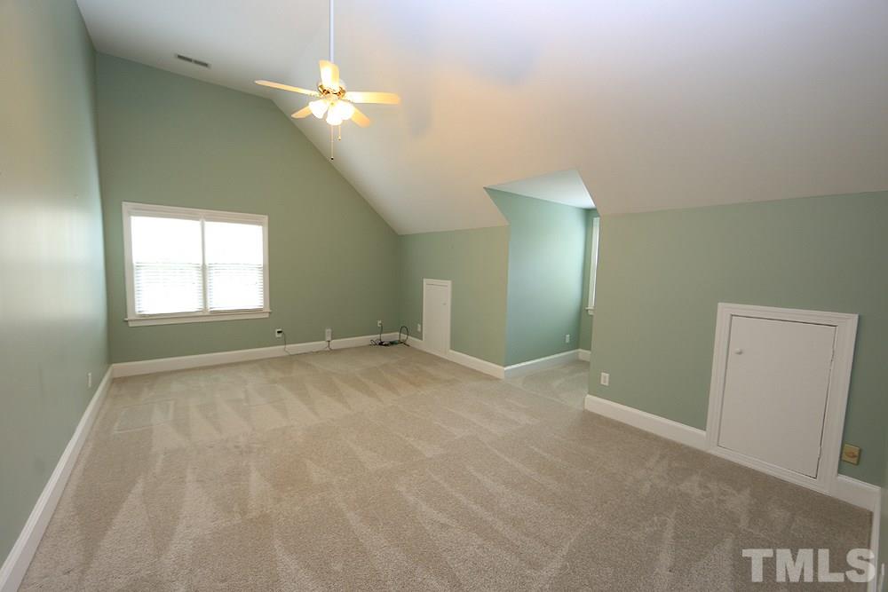 8203 Kitzel Way Raleigh, NC 27615 - Photo 11 of 14 an empty room with a chandelier fan and windows