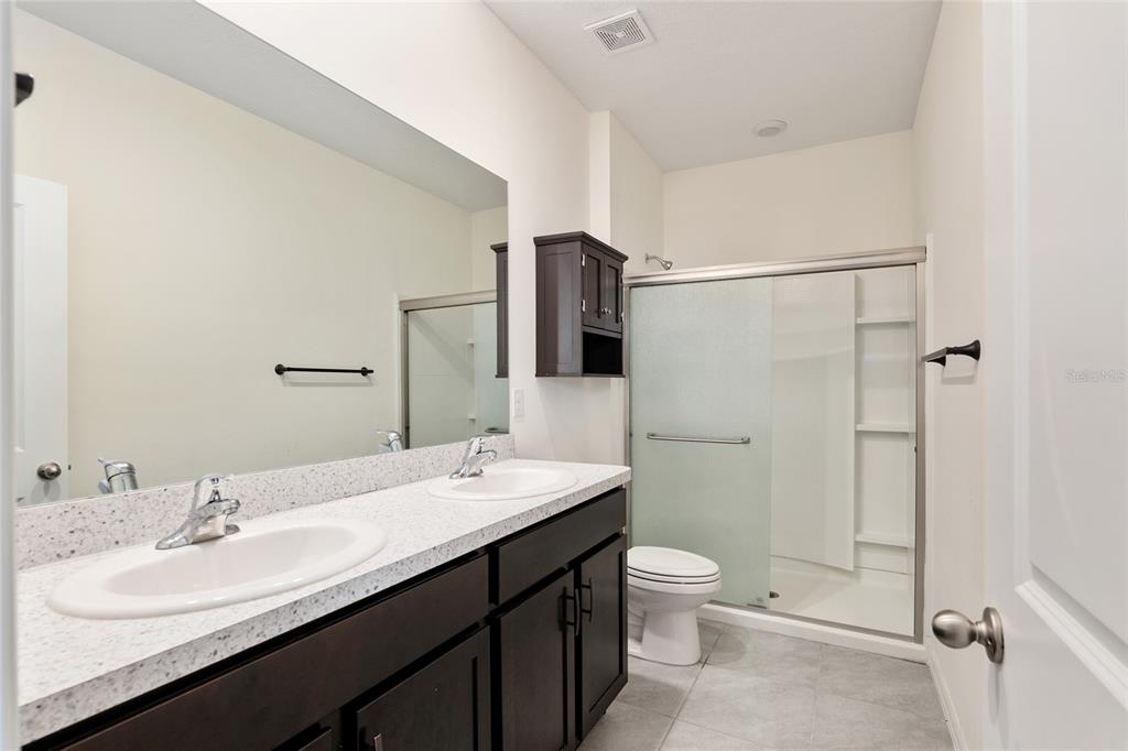 13818 Northwest 9th Road Newberry, FL 32669 - Photo 23 of 56 a bathroom with a double vanity sink toilet mirror and shower