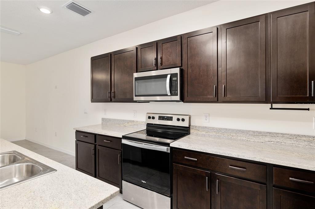 13818 Northwest 9th Road Newberry, FL 32669 - Photo 33 of 56 a kitchen with sink cabinets and microwave