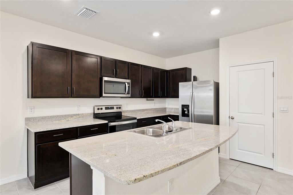 13818 Northwest 9th Road Newberry, FL 32669 - Photo 8 of 56 a kitchen with stainless steel appliances a microwave and refrigerator