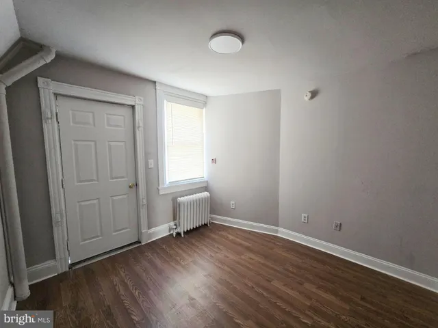 a view of a room with wooden floor and window