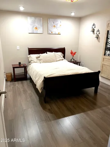 a bedroom with a bed and wooden floor