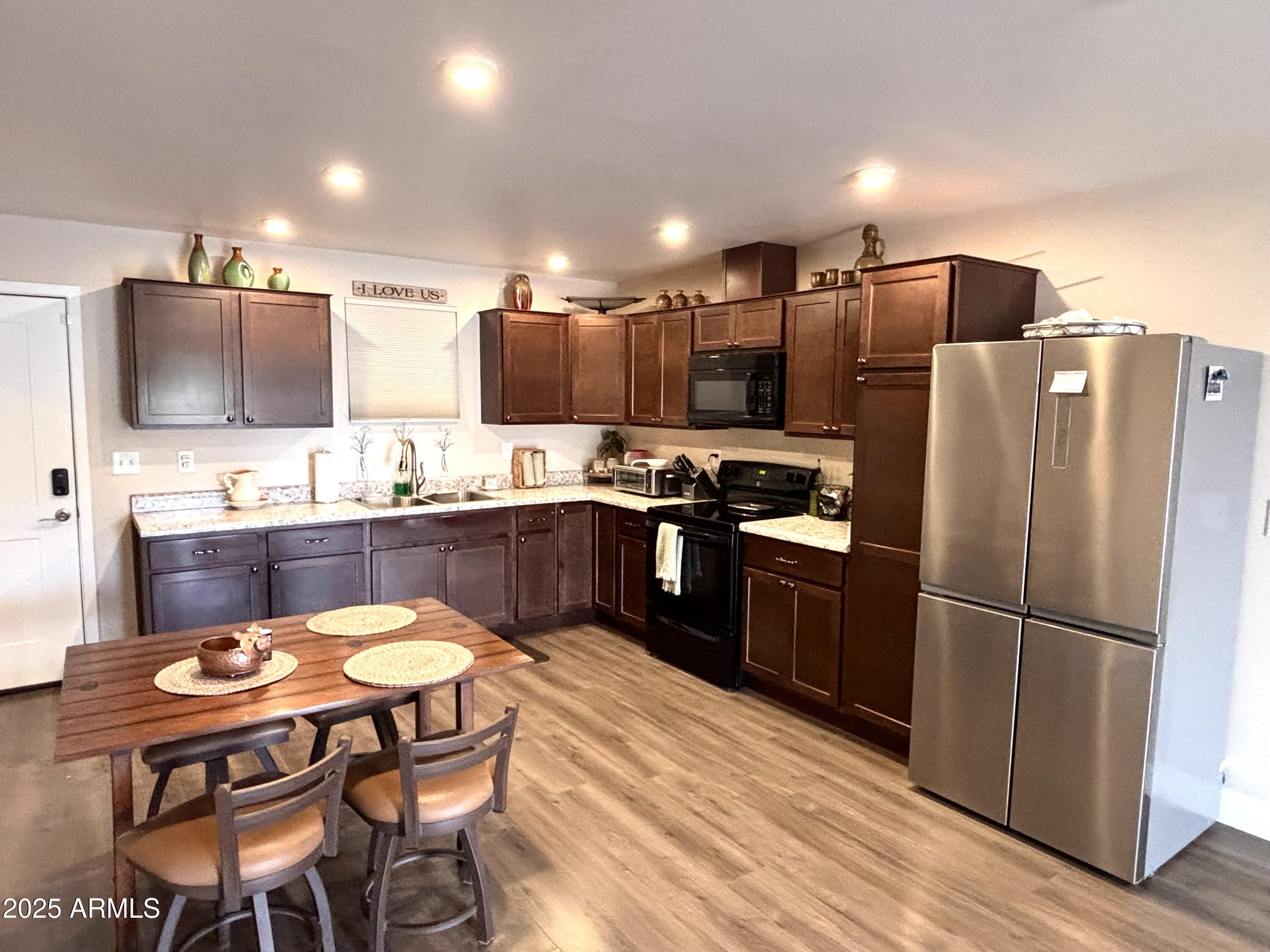 311 Solana Avenue Ajo, AZ 85321 - Photo 5 of 22 a kitchen with stainless steel appliances wooden floor and chairs